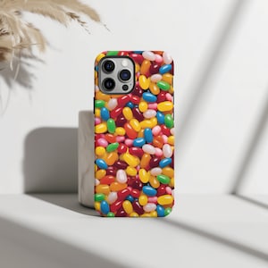 May include: A phone case with a colorful jelly bean design. The case is black and has a camera cutout.