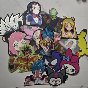 May include: A collection of colorful anime and cartoon character stickers. The stickers feature characters from various anime series, including Sailor Moon, Dragon Ball, and Spy x Family. The stickers are die-cut and have a glossy finish.