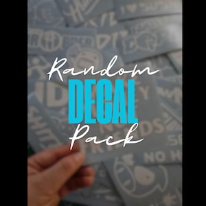 May include: A collection of white decals with various designs and text, held in a hand. The words "Random DECAL Pack" are written in white and blue. The background is a blurred assortment of more decals.