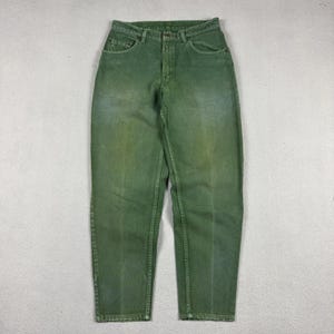May include: A pair of high-waisted denim jeans in a faded olive green color. These jeans feature a classic five-pocket design, a button and zipper fly closure, belt loops at the waistband, and visible stitching along the seams and pockets.