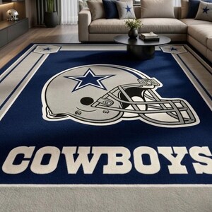 Puede incluir: Una alfombra rectangular con fondo azul oscuro y un gr&aacute;fico grande de un casco de f&uacute;tbol americano plateado en el centro. El casco muestra un logotipo de estrella azul. La palabra COWBOYS est&aacute; impresa en letras may&uacute;sculas blancas abajo.