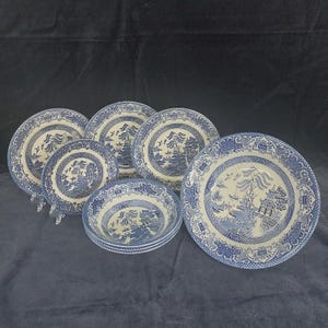 Könnte beinhalten: Ein Set aus blau-weißem Willow-Muster-Porzellan. Das Set umfasst Teller und Schalen in verschiedenen Größen. Die Teller und Schalen zeigen ein detailliertes Landschaftsdesign mit einer Pagode, einer Brücke und Vögeln. Die Ränder haben eine dekorative Bordüre.