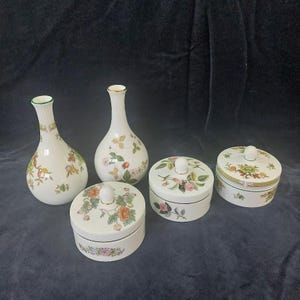 Peut inclure: Ensemble de vases et de pots en céramique blanche avec couvercles. Les vases ont un col fin et sont décorés de motifs floraux et fruités. Les pots sont ronds avec des motifs floraux assortis. Idéal pour la décoration intérieure.