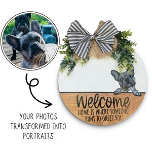 May include: A round wooden welcome sign with a painted French Bulldog illustration. The sign has a white and wood grain finish, a striped bow, and greenery. Text reads "Welcome, Home is where someone runs to greet you."