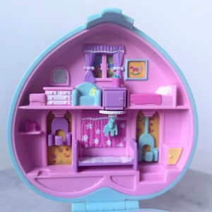 Pu&ograve; includere: Una casetta di giocattolo in plastica rosa e blu con un'apertura a forma di cuore. L'interno della casa &egrave; decorato con mobili e accessori, tra cui un letto, una cassettiera, una sedia e un comodino. La casa &egrave; progettata per essere un set di gioco per bambini.