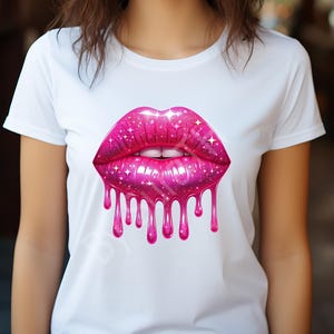 May include: White t-shirt featuring a large, vibrant pink lip design. The lips have a sparkling, glittery texture with dripping liquid effect. The design includes white teeth and a glossy finish, creating a bold and eye-catching graphic.