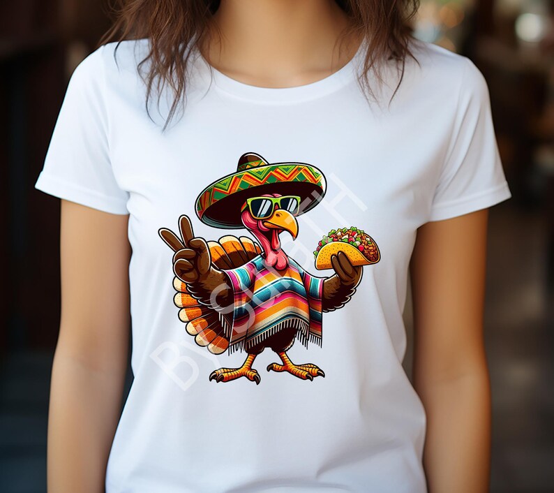 May include: White t-shirt featuring a cartoon turkey wearing a sombrero and sunglasses, with a colorful poncho and holding a taco. The turkey is making a peace sign with its left hand. The design is vibrant and playful.