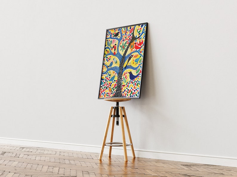 Op de afbeelding: Een kleurrijke ingelijste print van een boom met vogels en bloemen op een gele achtergrond. De print wordt getoond op een houten kruk.