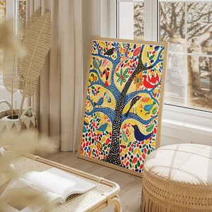 Op de afbeelding: Een kleurrijke ingelijste print van een boom met vogels en bladeren. De boom is blauw met een zwarte stam en de bladeren zijn geel, rood, groen en oranje. De vogels zijn blauw, rood, geel en groen.
