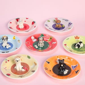 May include: Set of seven colourful ceramic trinket dishes featuring various dog breeds and cat breeds. Each dish has a different design and features a small figurine of a dog or cat.