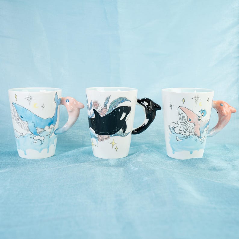 Puede incluir: Tres tazas de cer&aacute;mica con dise&ntilde;os de ballenas y orcas. Cada taza tiene un asa en 3D de ballena u orca.