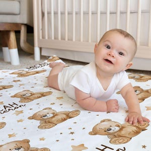 a baby laying on a blanket on the floor