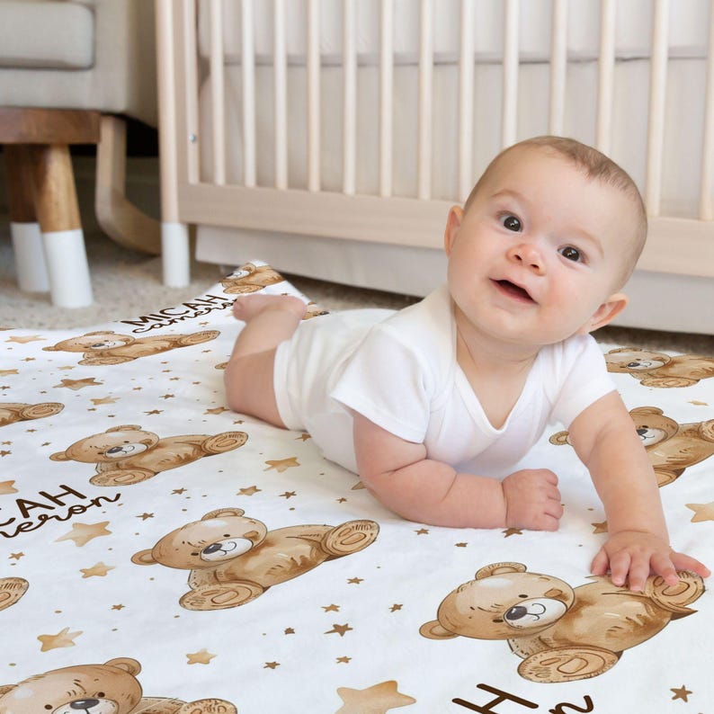 a baby laying on a blanket on the floor