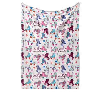 a white blanket with a repeating pattern of roller skates and flowers printed on it.