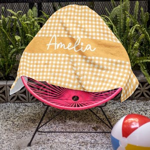 a pink chair with a yellow and white cover on it
