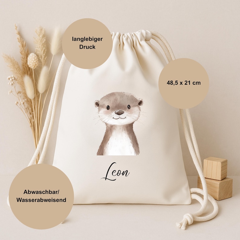Op de afbeelding: Een cr&egrave;mekleurige trekkoordtas met een aquarel illustratie van een schattige otter. De tas meet 48,5 x 21 cm en heeft de naam "Leon" onder de otter gedrukt. De tas heeft een duurzame print en is wasbaar en waterafstotend.