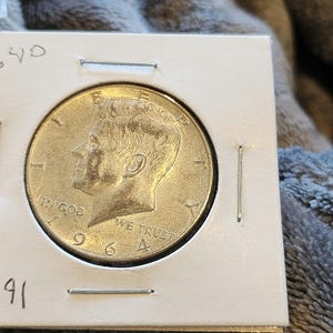 John F. Kennedy Brilliant Uncirculated 1964 Silver Half Dollar along with the Almost Uncirculated 1966 JFK half dollar.