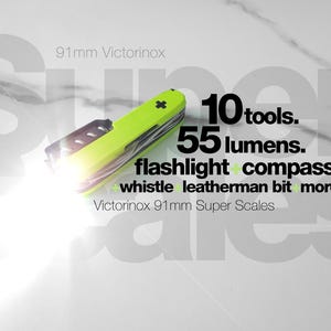 May include: A lime green 91mm Victorinox multi-tool with an integrated flashlight emitting a bright white beam. Text on the image reads: 10 tools. 55 lumens. flashlight + compass + whistle + leatherman bit + more. Victorinox 91mm Super Scales.