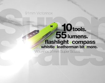 May include: A lime green 91mm Victorinox multi-tool with an integrated flashlight emitting a bright white beam. Text on the image reads: 10 tools. 55 lumens. flashlight + compass + whistle + leatherman bit + more. Victorinox 91mm Super Scales.