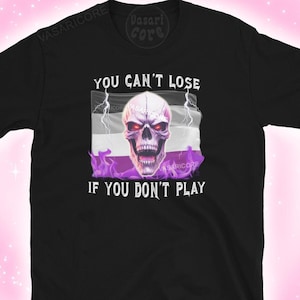 Puede incluir: Camiseta negra con una bandera de orgullo asexual púrpura, blanca y negra con una calavera y rayos. El texto "You can't lose if you don't play" está impreso debajo de la bandera.