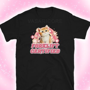 Può includere: Maglietta nera con una grafica rosa e bianca di un gatto con il testo "Forklift Certified" in rosa.
