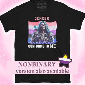 Peut inclure: T-shirt noir avec un motif graphique représentant un squelette tenant un verre, avec le texte "GENDER CONFORMS TO ME". Le motif comprend un drapeau non binaire et des éclairs. Le texte "NONBINARY version also available" est également présent.