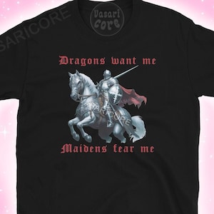 Może przedstawiać: Czarny T-shirt z grafiką przedstawiającą rycerza na białym koniu. Na koszulce nadrukowany jest tekst "Dragons want me" i "Maidens fear me".