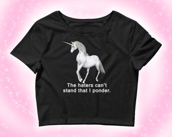 May include: Black cropped t-shirt with a white unicorn graphic and the text "The haters can't stand that I ponder."