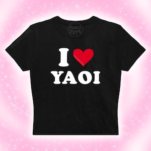 May include: Black crop top with the text "I ♥ YAOI" in white, with a red heart replacing the word "love". The shirt has short sleeves and a crew neck. The brand name "VASARICORE" is printed on the shirt.