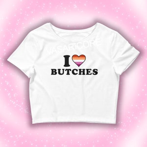 May include: White cropped t-shirt with a black heart and the text "I love butches" in black. The heart is filled with the lesbian pride flag colors.