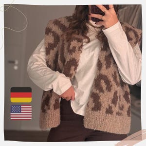 May include: A sleeveless vest with a brown and tan animal print pattern. The vest is worn over a white long-sleeved shirt and brown pants. The image is taken indoors, with a neutral background.
