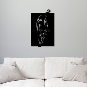 K&ouml;nnte beinhalten: Schwarze Wandkunst aus Metall mit einer stilisierten Silhouette eines Panthers, der auf den Betrachter zugeht.