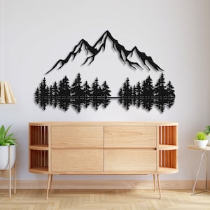 May include: Black metal wall art depicting a mountain range with a reflection of trees in a lake. The art is mounted on a white wall above a wooden dresser.