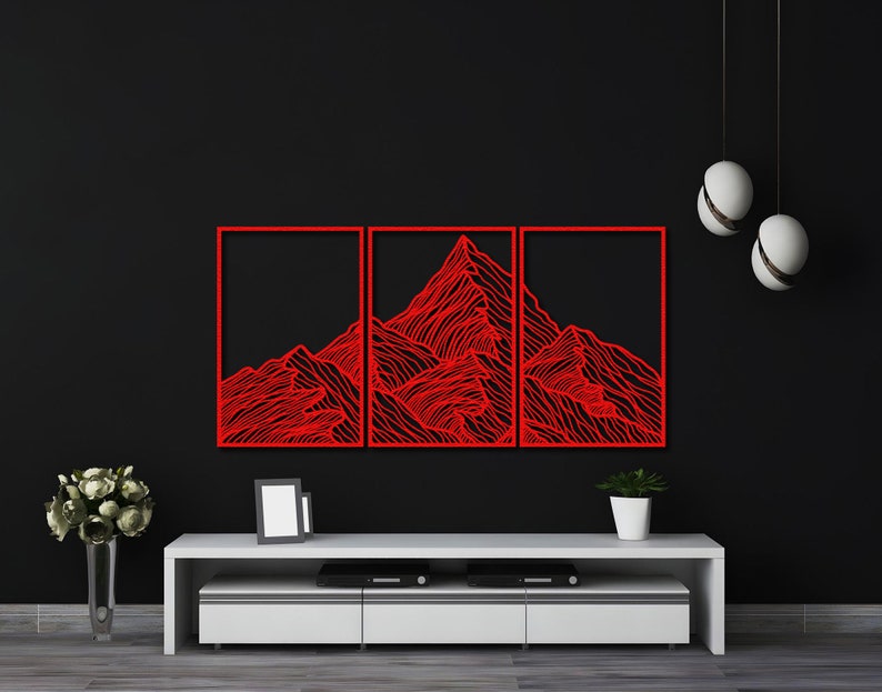 May include: Three red metal wall art panels depicting a stylized mountain range. The panels are mounted on a black wall above a white entertainment center.