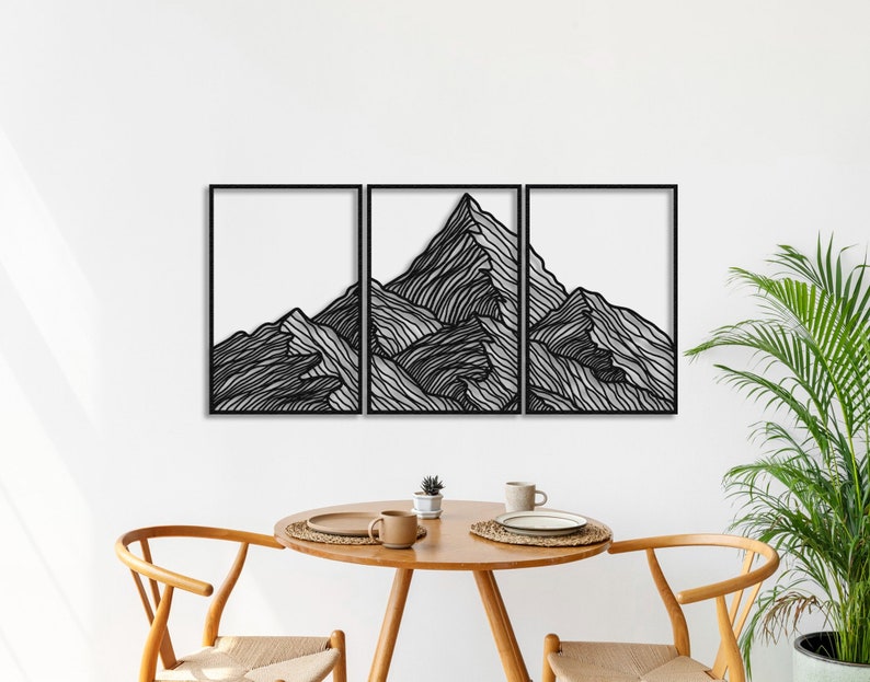 May include: Black metal wall art depicting a stylized mountain range. The art is divided into three panels, each featuring a different section of the mountain range. The art is mounted on a white wall.