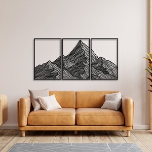 May include: A black metal wall art sculpture depicting a mountain range with a minimalist line art design. The sculpture is divided into three panels.