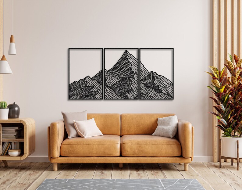 May include: A black metal wall art sculpture depicting a mountain range with a minimalist line art design. The sculpture is divided into three panels.