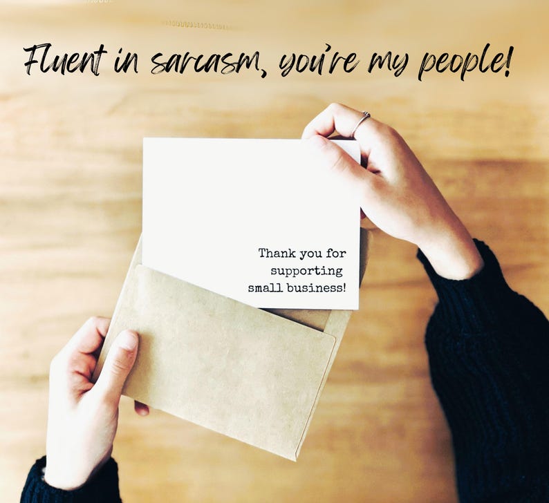 Puede incluir: Una tarjeta rectangular blanca dentro de un sobre color canela. La tarjeta tiene el texto impreso en negro: Thank you for supporting small business! Arriba, el texto negro dice: Fluent in sarcasm, you're my people! La tarjeta est&aacute; sujeta.