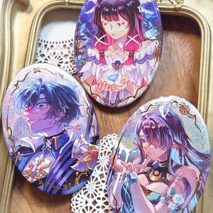 May include: Three oval-shaped pinback buttons featuring detailed anime-style illustrations of characters. The top button shows a figure with dark hair and pink highlights, the left shows a blue-haired character, and the right shows a purple-haired figure.