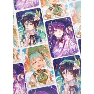 May include: A selection of rectangular stickers showcasing anime-style illustrations of characters in vivid colours. The characters have detailed facial features, set against various coloured backgrounds. The stickers are arranged closely together.