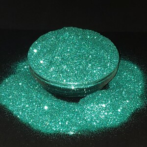 May include: A close-up of teal green glitter, a popular material for crafting and decorating.