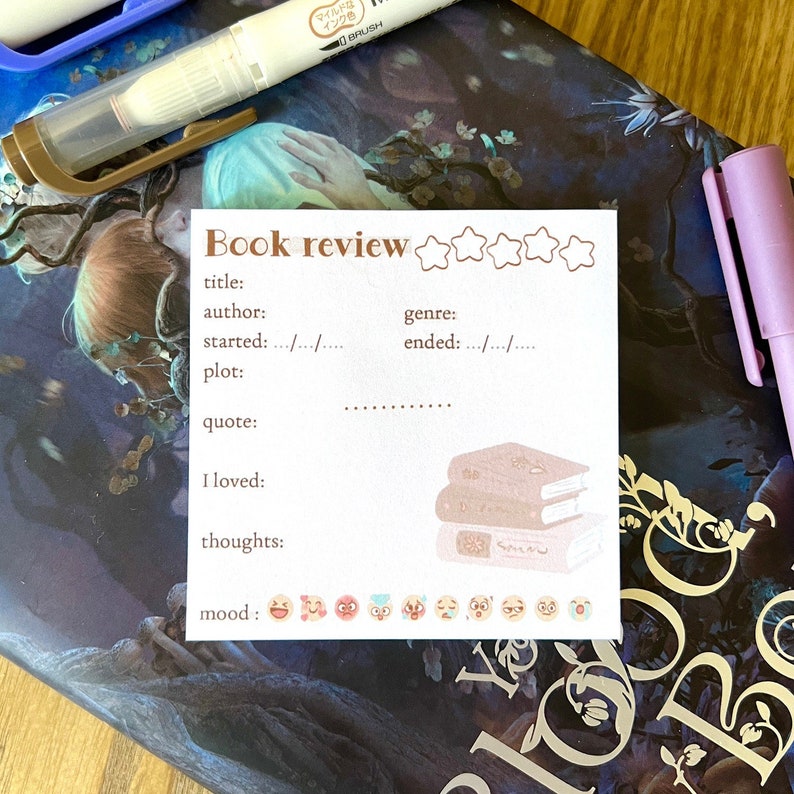 May include: A white book review template with a brown border. The template has sections for title, author, genre, started, ended, plot, quote, I loved, thoughts, and mood. There are five stars at the top of the template and a stack of books in the bottom right corner. There are also a series of emojis below the mood section.