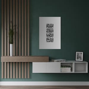 Op de afbeelding: Een wit zwevend rek met een houten bovenblad en drie vakken. Het rek is gemonteerd aan een groene muur met een zwart-witte print van Arabische kalligrafie erboven.