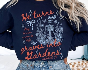 May include: Navy blue sweatshirt with the text "He turns dry bones into graves into Gardens" and a skeleton graphic surrounded by flowers and butterflies. The text "Ezekiel 37" is also included.