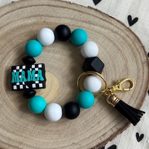 Llavero de pulsera Mamá con cuentas de silicona turquesa, blanca y negra y cierre de mosquetón.