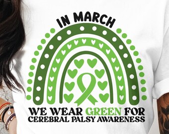 May include: White t-shirt with a green and black rainbow design and the text "In March We Wear Green for Cerebral Palsy Awareness".