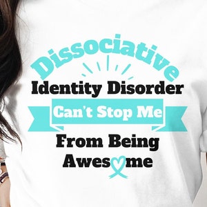 May include: White t-shirt with the text "Dissociative Identity Disorder Can't Stop Me From Being Awesome" in teal and black. The design includes a teal ribbon and a heart symbol.