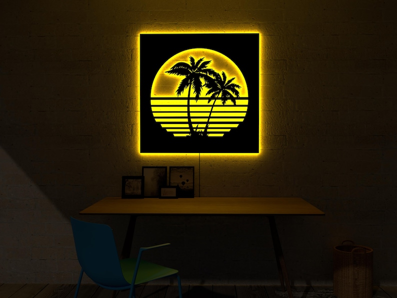 May include: A backlit wall art piece featuring a black silhouette of palm trees and a setting sun design. The artwork is illuminated with a warm yellow glow, creating a tropical aesthetic. The piece is square and mounted on a wall.