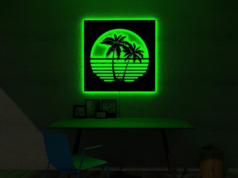 May include: A neon green backlit wall art piece featuring a black silhouette of palm trees against a sunset design. The artwork is square and mounted on a dark wall. A desk and chair are below the artwork.