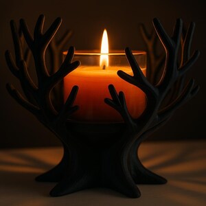 May include: A black, tree-shaped candle holder with a lit orange candle inside a glass. The candle flame is bright against the dark background. The holder has a detailed, antler-like design.